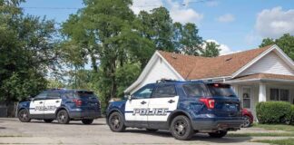Illinois Mother Charged in Death of 2-Year-Old Son Two police SUVs parked near a suburban house