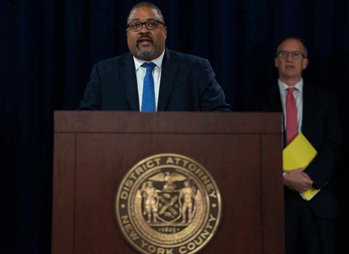 shutterstock_2199567225 Man speaks at podium with New York County District Attorney seal