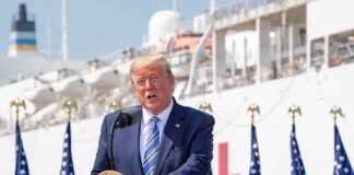 Trump Makes Crime a Key NC Senate Issue man in suit speaking at a podium with flags and a ship behind