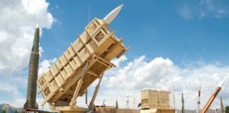 Patriot missile defense system on display outdoors with various missiles in the background