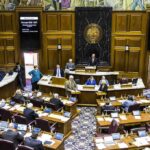 Legislative chamber with lawmakers debating a bill