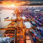 China Hits 14 EU Entities in Escalating Trade War Container port with cranes and cargo ships at sunset