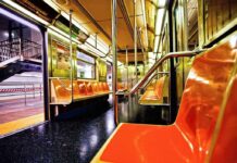 Empty subway car with orange seats and open doors