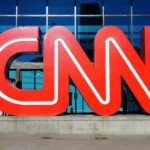 CNN red logo sculpture outside a glass-fronted building
