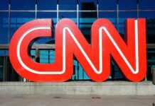 CNN red logo sculpture outside a glass-fronted building