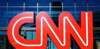 CNN red logo sculpture outside a glass-fronted building