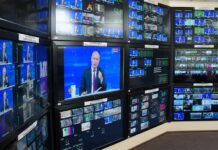 Two Nations Face Rising Security Challenges Vladimir Putin on multiple control room monitors