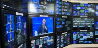Two Nations Face Rising Security Challenges Vladimir Putin on multiple control room monitors