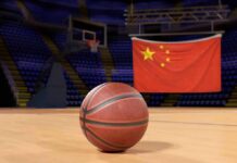Former Player Vows to Expose NBA’s China Dealings Basketball on an indoor court with a Chinese flag in the background