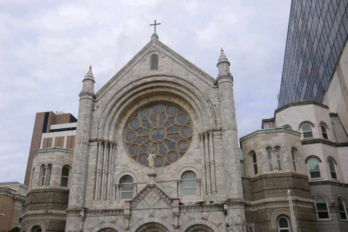 Stone church facade with large rose window and cross