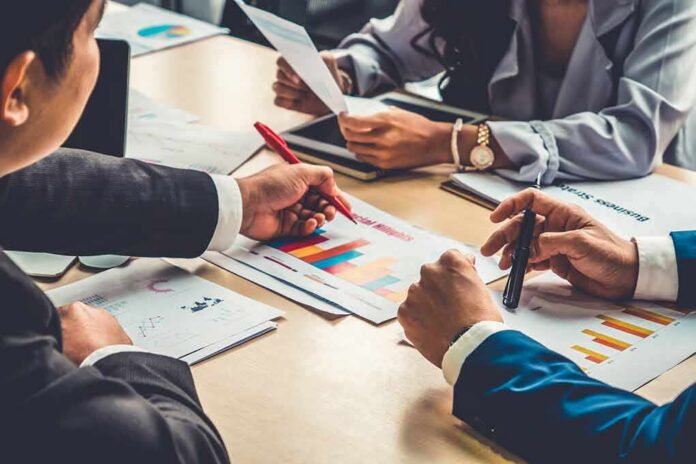 shutterstock_1767864710 business team reviewing charts at a meeting table