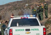 West Texas Border Agents Face New Threat Border Patrol agents gather near fence with patrol trucks