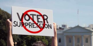 General Rules Out Troops at Polls Protester holding a sign in front of a government building