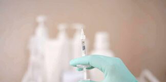 Gloved hand holding a syringe
