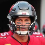 NFL Icon’s Death Prompts Tributes football player in helmet and red jersey looking forward