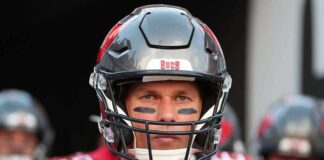 NFL Icon’s Death Prompts Tributes football player in helmet and red jersey looking forward