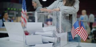 DOJ Challenges Alaska Senate Election Person casting a ballot into a clear box at a polling station