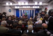 Republican Senator Pushes MMR Shots Amid Outbreak Press secretary at podium addressing reporters in briefing room